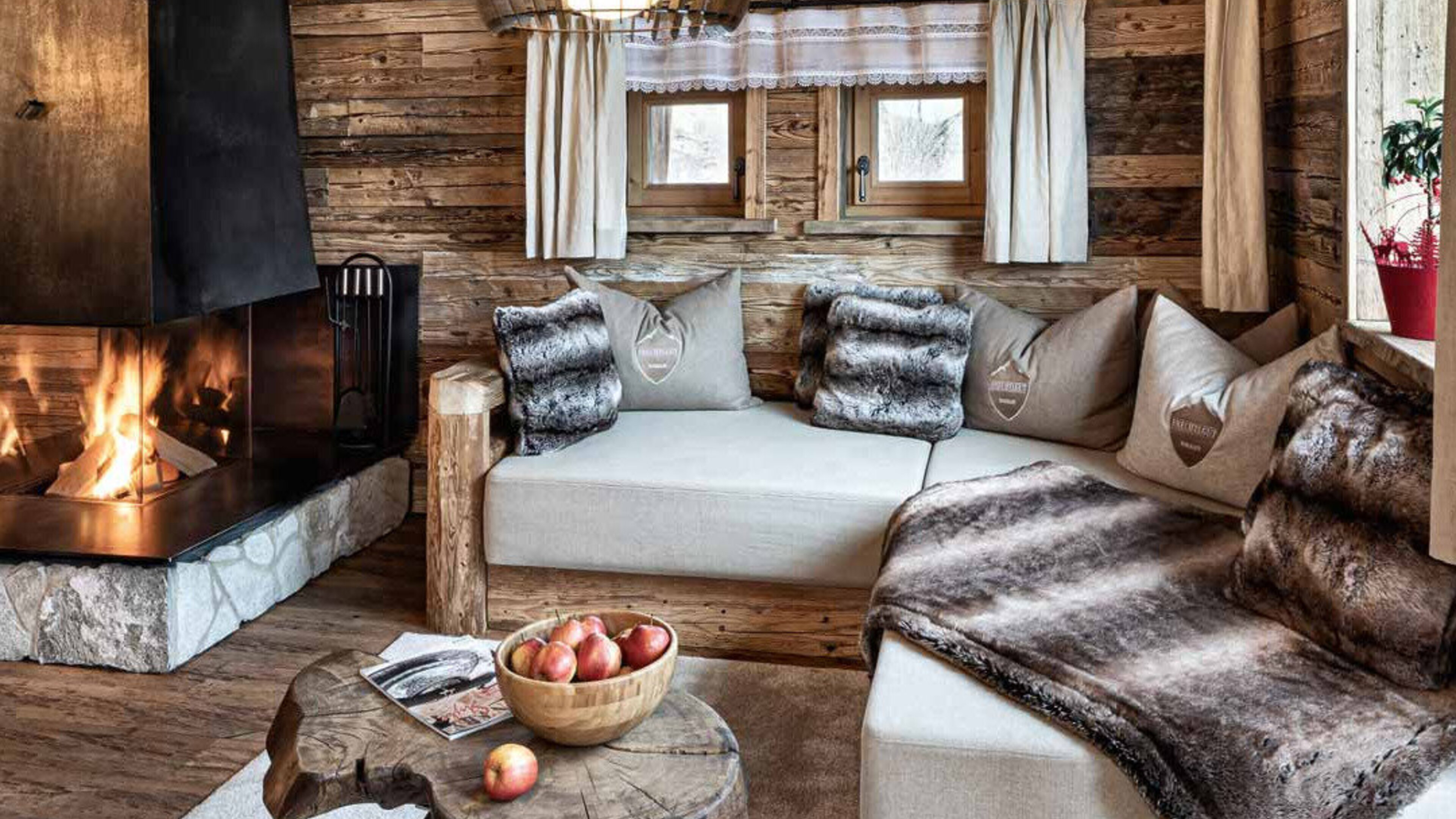 Chalet-Wohnzimmer mit Kamin und Webpelzdecken von Mattex im Bergdorf Prechtlgut in Wagrain