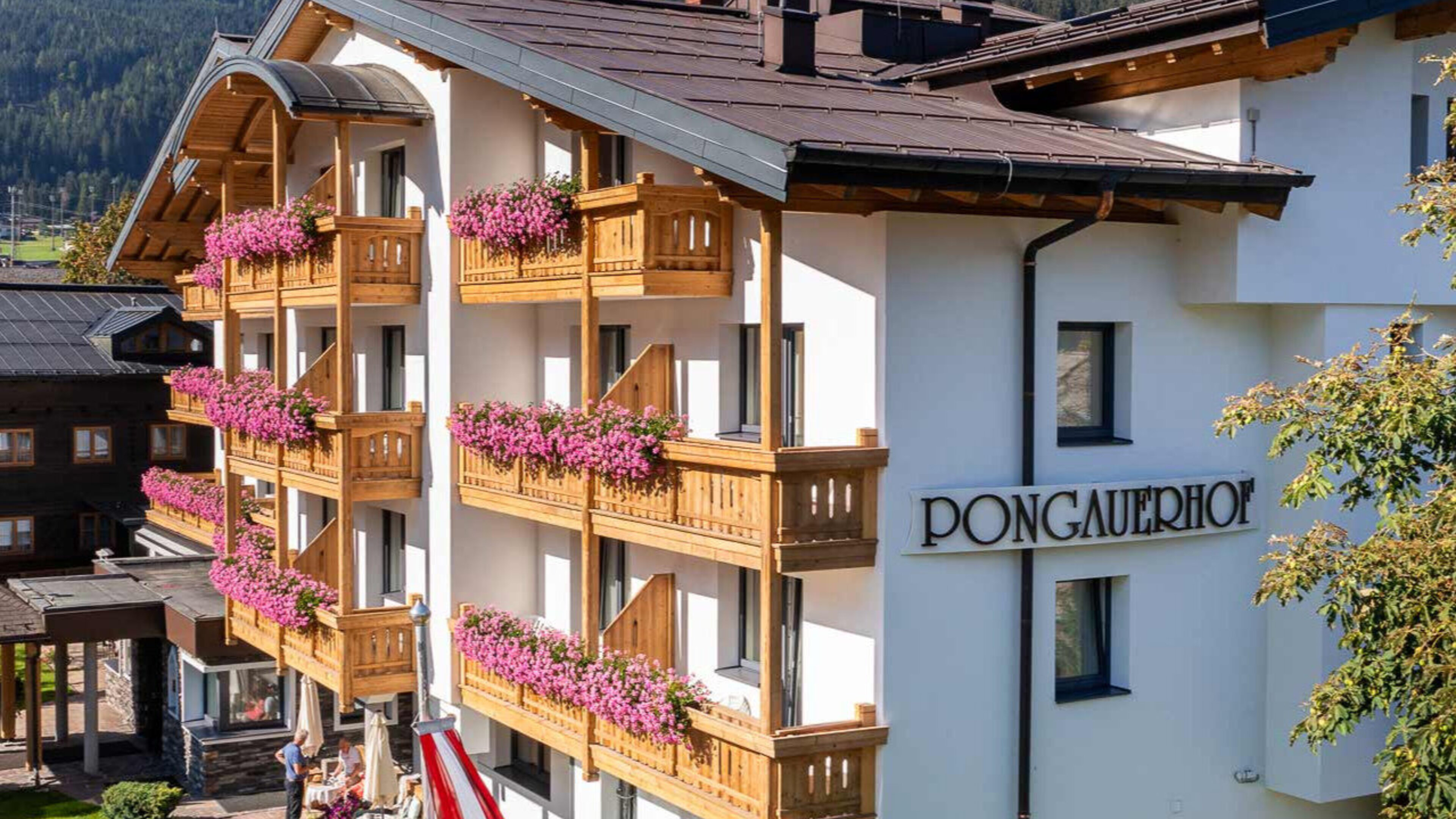 Außenansicht des 4-Sterne-Hotels Pongauerhof in Flachau mit Blumenbalkonen