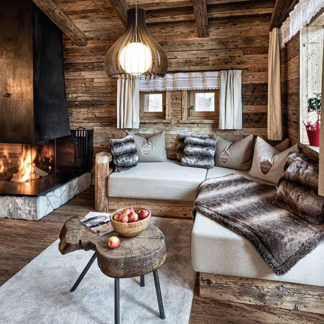 Chalet-Wohnzimmer mit Kamin und Webpelzdecken von Mattex im Bergdorf Prechtlgut in Wagrain